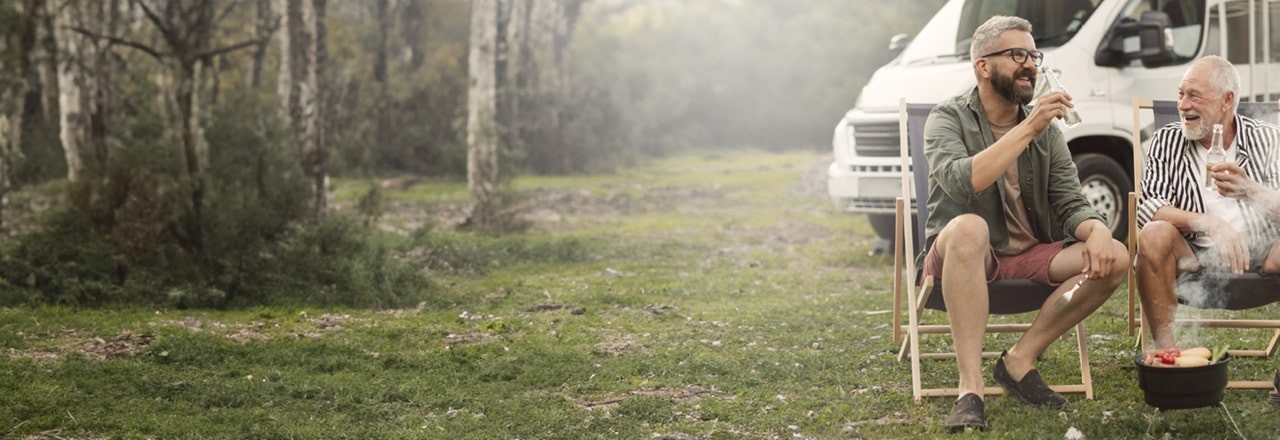 Lachende M&auml;nner beim Camping